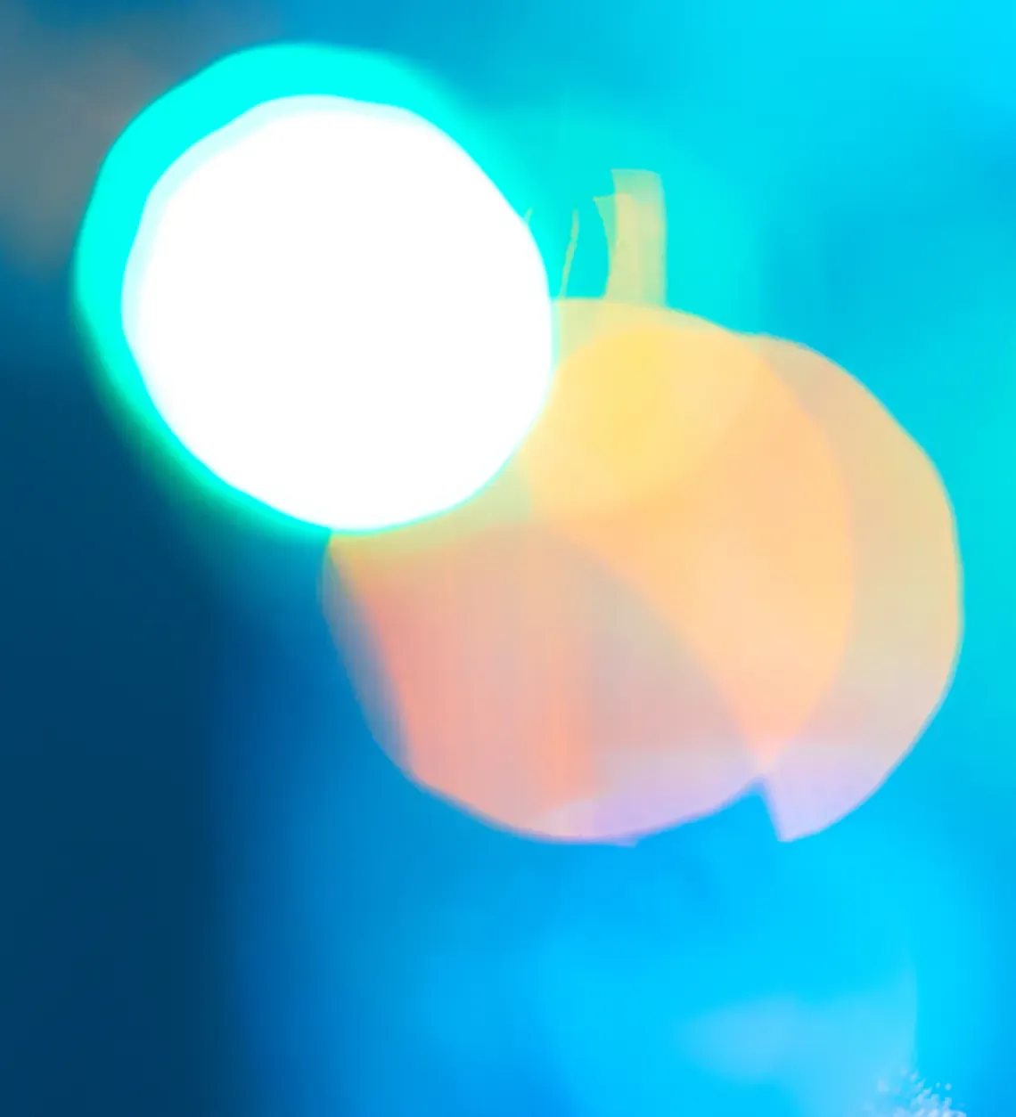 Halos de lumière turquoise et pêche en flou d'arrière-plan