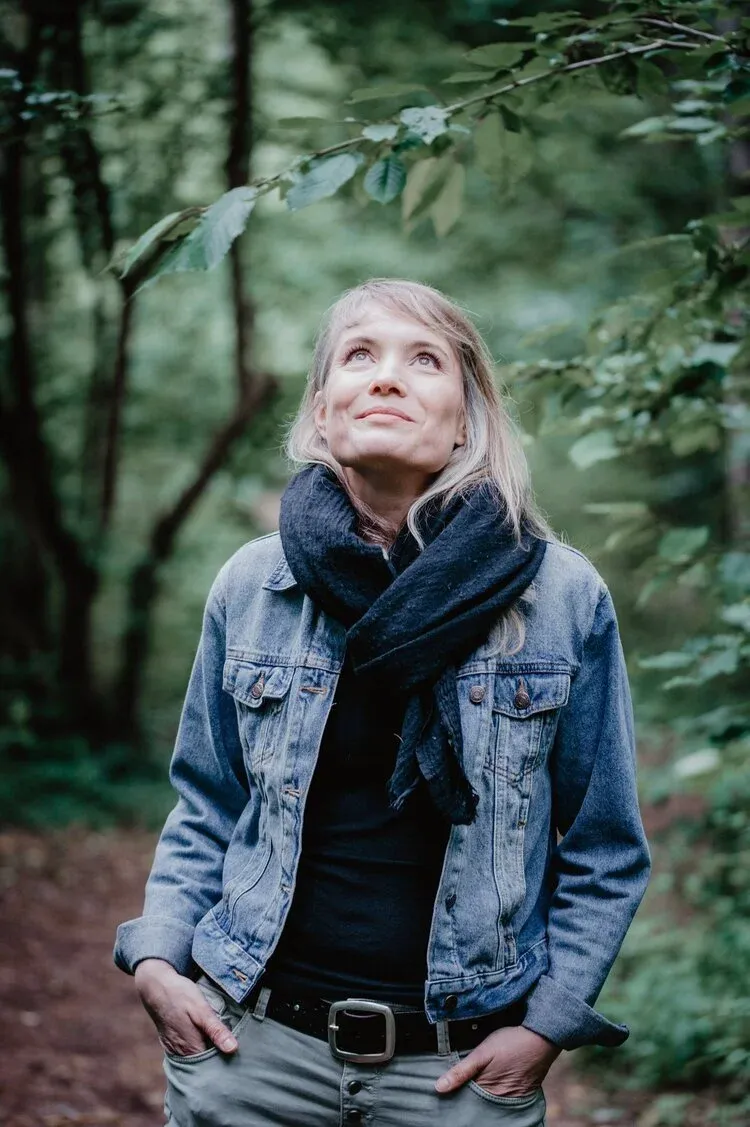 Fanny Clerc en forêt, le regard tourné vers la cime des arbres
