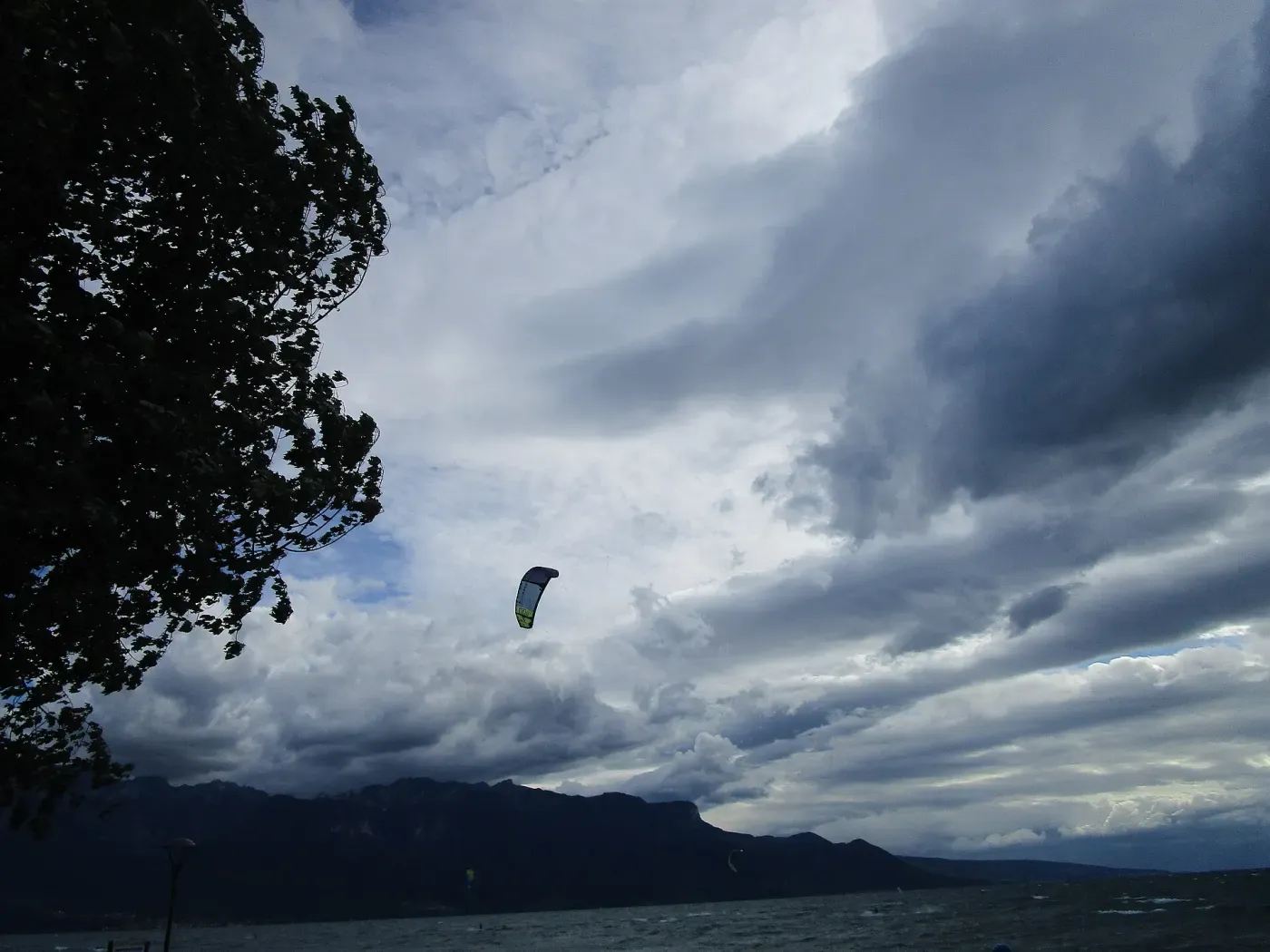 Une aile de kite sous un ciel d’orage au-dessus du Léman