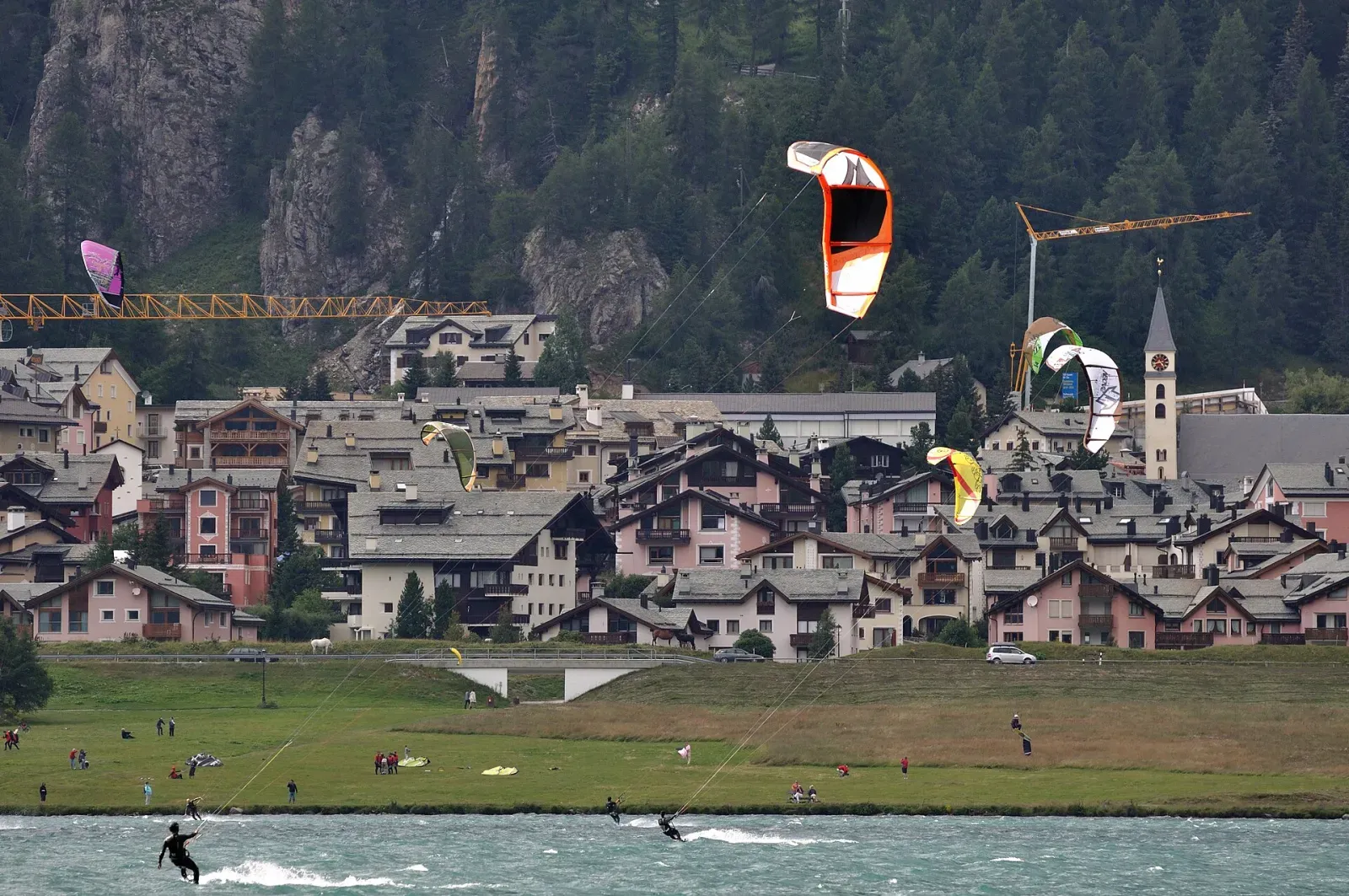 Des ailes de kite au-dessus d’un village de montagne au bord du lac